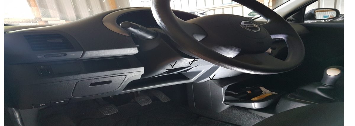 Innenraum eines Nissan Micra: die Verkleidung unter dem Lenkrad mit markierten Schraubpunkten